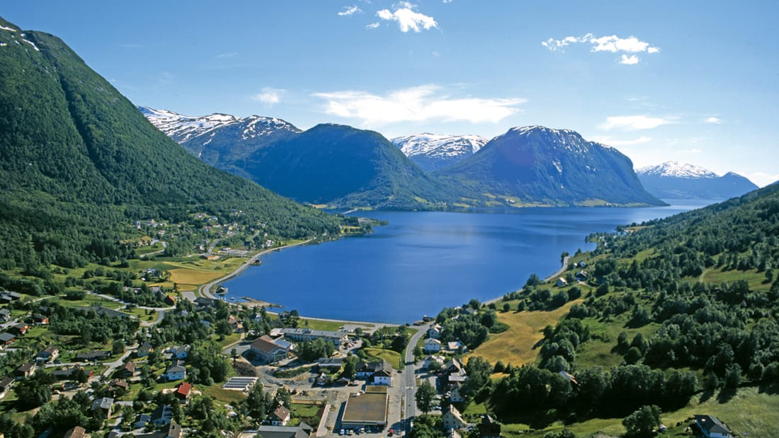 Norske fjorder med snødekte fjell og klart blått vann.