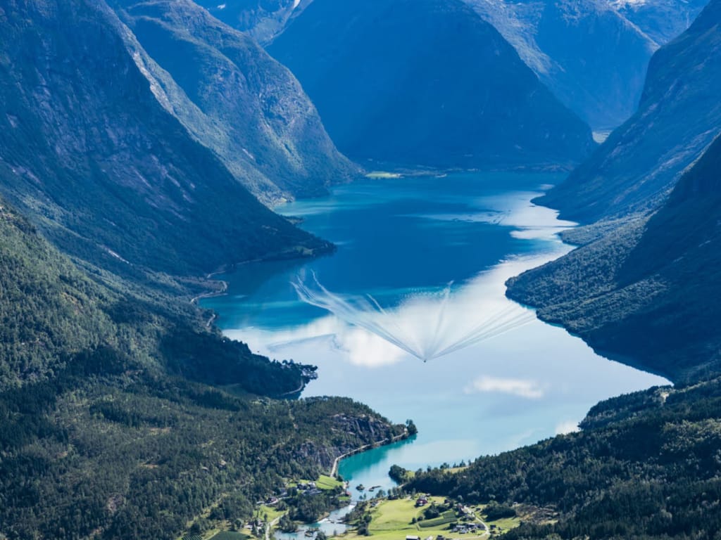 Majestetiske fjell omkranser de dype, rolige vannene i de vakre fjordene i Norge.